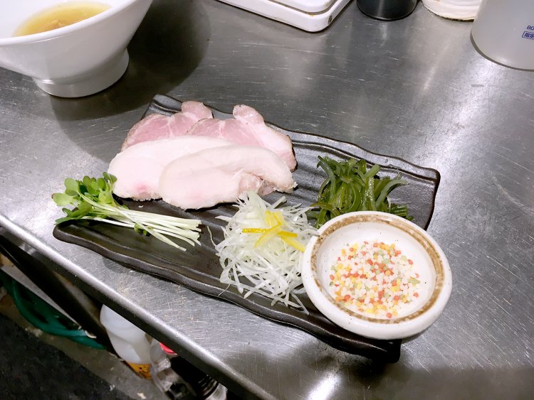 具材は豚チャーシューと鶏チャーシュー、茎わかめ、かいわれ、エビのつみれ、たまご、あられ。