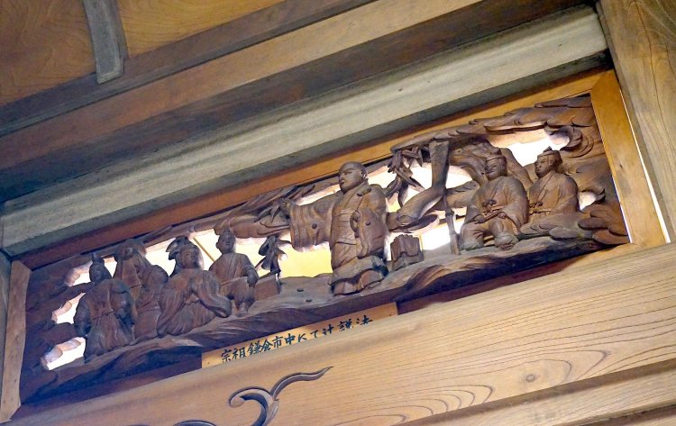 本堂の欄間に刻まれた、鎌倉市中で辻説法をする日蓮聖人の姿。現代の政治家が街で人々に訴える姿にも重なる。