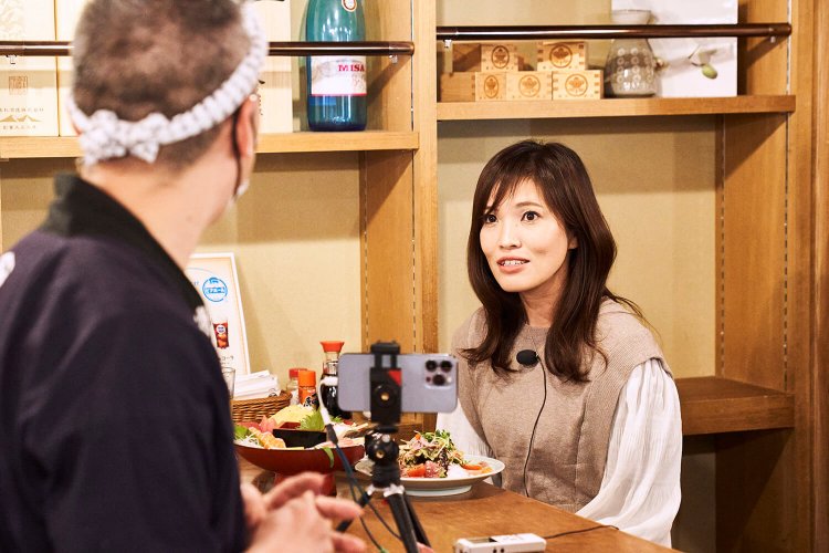 動画撮影もしながらインタビュー。「店によってメニューが違うので、徳田酒店だけでハシゴ酒ができますよ」と、店長の浅見さん。