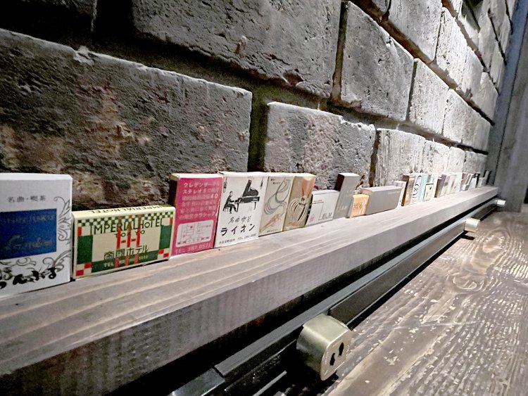 カウンター席に飾られているマッチコレクション（ただし店内は全面禁煙）と電源コンセント。USBのACアダプターも貸し出してくれる。