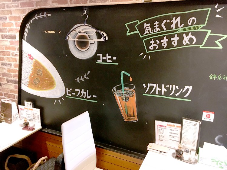 壁には大きな黒板があり、おすすめメニューのイラストが描かれている。