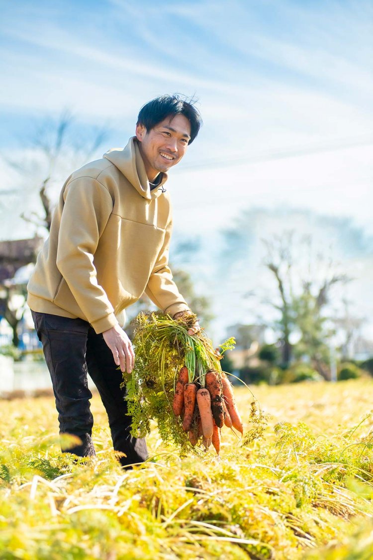 種まきから約半年、2月上旬からの収穫期間に向け、生育状況をチェックする小寺良治さん。実際の収穫は機械で行われる。