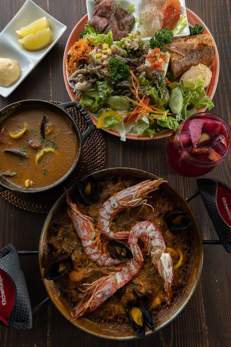 パエリア1650円～、カルドソ2255円～ほか。ランチの前菜盛り合わせ（奥）はボリューミーでお酒にも合う。