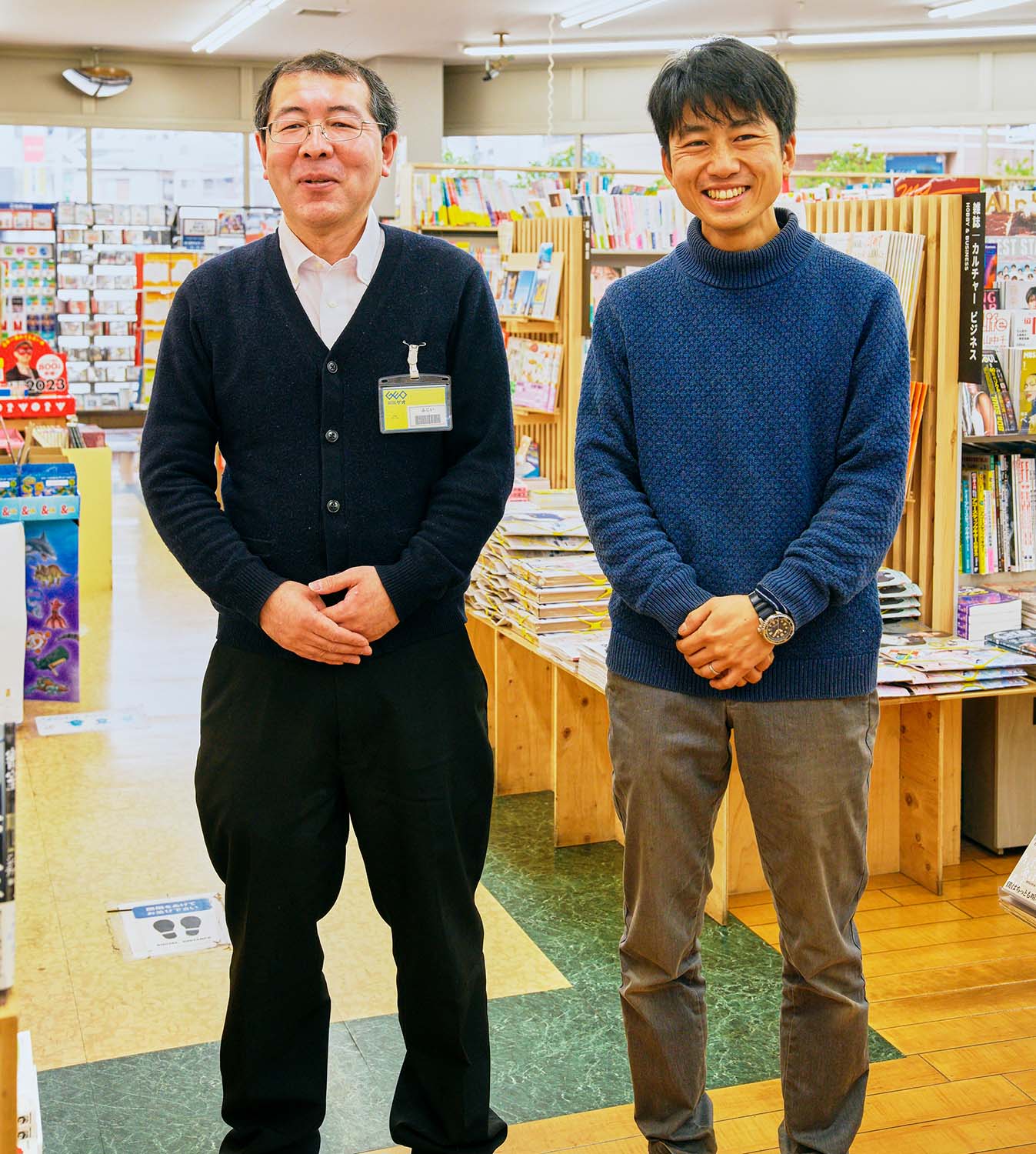 専務の野崎林太郎さん（右）と、「手塚治虫さんは晩年を東久留米で暮らしました。駅前にブラック・ジャック銅像もあります」と話す店長の藤井直也さん（左）。