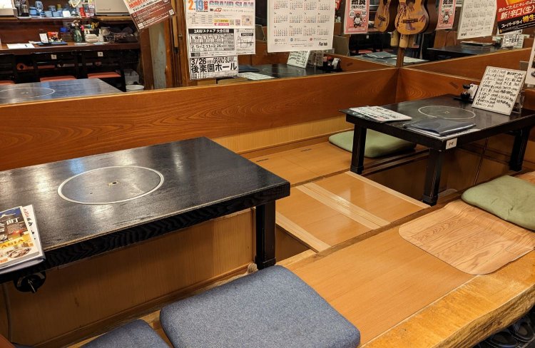 鏡張りの壁に囲まれた座敷。床に座り、ゆっくりと料理を味わえる。