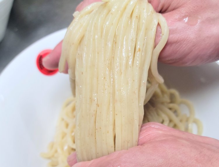 丼に艶やかな太麺をきれいに畳み込む。