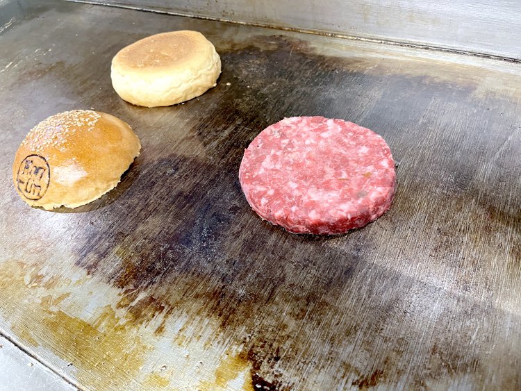 鉄板の上で焼かれるバンズとパテ。バンズもこんがりと焼き目が付くくらい焼く。