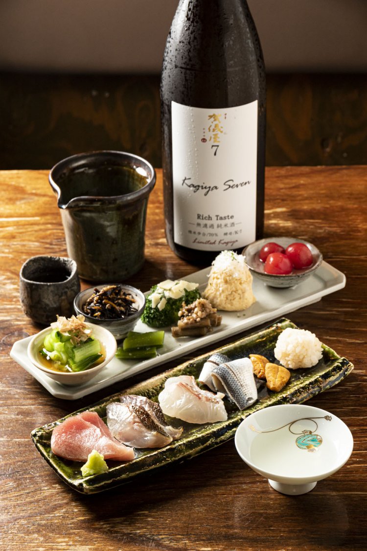 刺し身の盛り合わせ1580円～、スモークした白身が入るポテサラなど冷菜の盛り合わせ1人前900円。同店別注の賀儀屋セブン1合1280円。