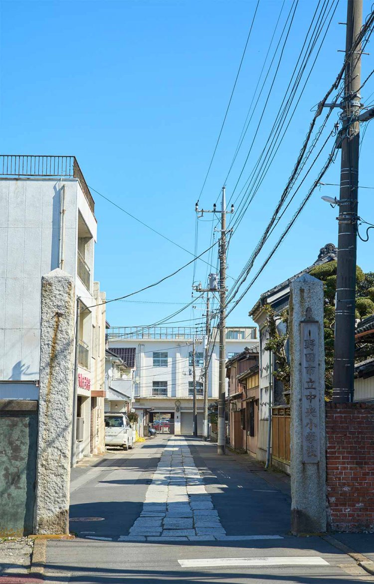 立派な石柱とレンガ塀は市立中央小学校の旧正門。石畳の道の先には昭和初期築の校舎が。