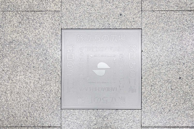 床には「旅立ちの広場」と刻まれたパネルが。