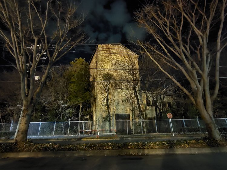 夜の美術館通りから望む基地内の建物。冬場になると草木が枯れて建物がより見えてくる。この建物は一部が高く、倉庫であったのだろうか。