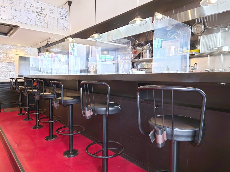 赤と黒を基調とした店内。入口を入ってすぐ、厨房を見渡せるカウンター7席。