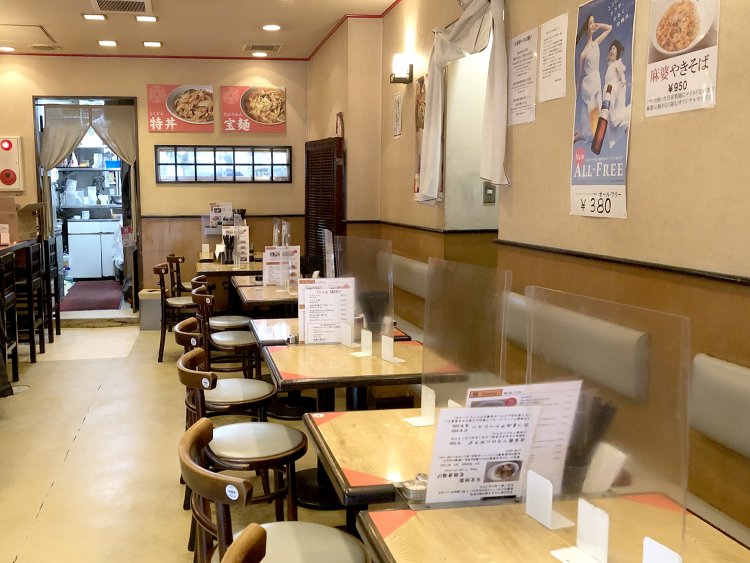 店内はアイボリー調の壁と木目の落ちついた雰囲気。カウンター席もある。