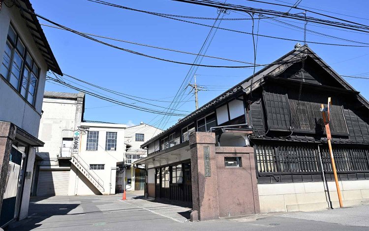 国登録有形文化財で明治30年（1897）築の事務所兼主屋（右）と大正10年（1921）築の旧火入れ場および変電室（奥）。