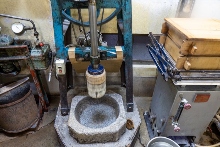 餅作りは店の奥で。今では珍しいタイプの餅つき機の隣でもち米が蒸されて、蒸気がいい匂い！