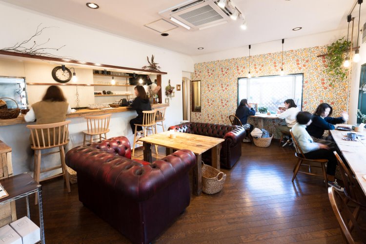 アンティークと花で調えた空間。花壇を望む窓辺席も人気だ。