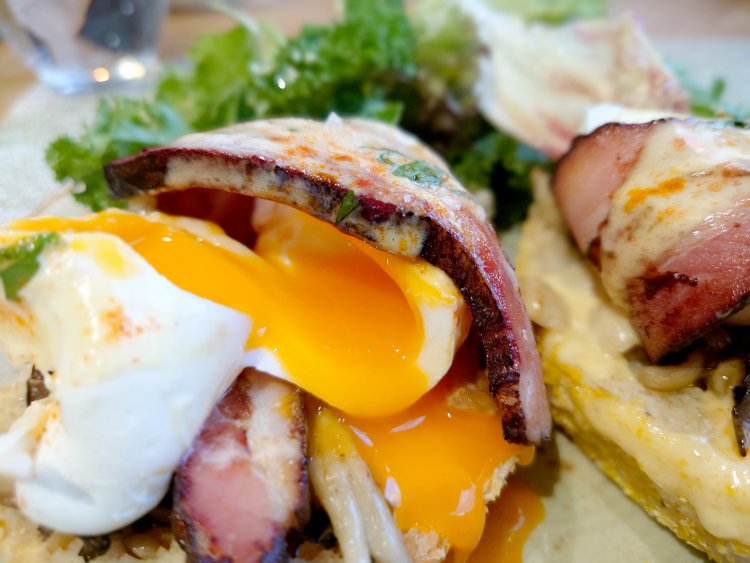 ポーチドエッグにナイフを入れると、中からトロトロ半熟の黄身がとろけ出す。