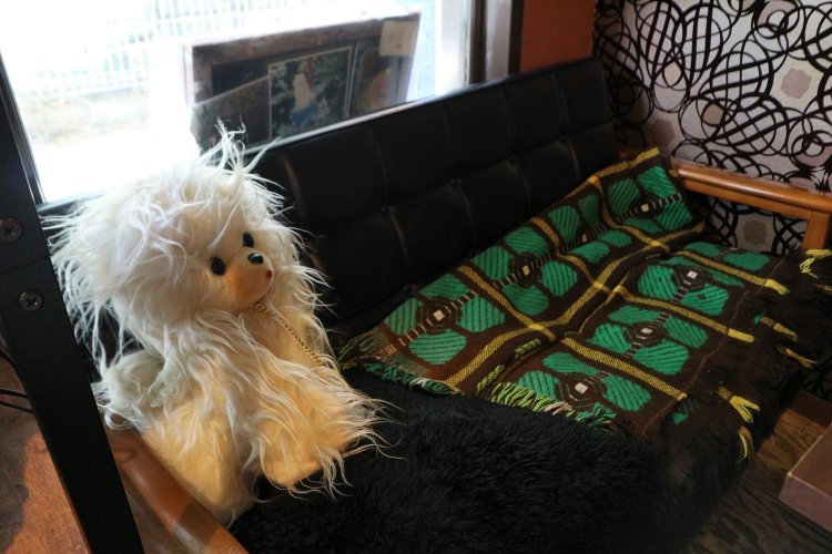 ソファにちょこんと座るのは、室内で飼う“座敷犬”が大ブームを起こした時代に生産された犬のぬいぐるみ。首には散歩用の鎖もついている。