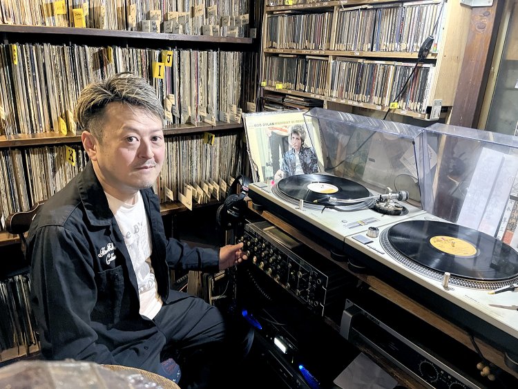 店長の山口英行さん。DJブースにはレコードやCDがぎっしり！