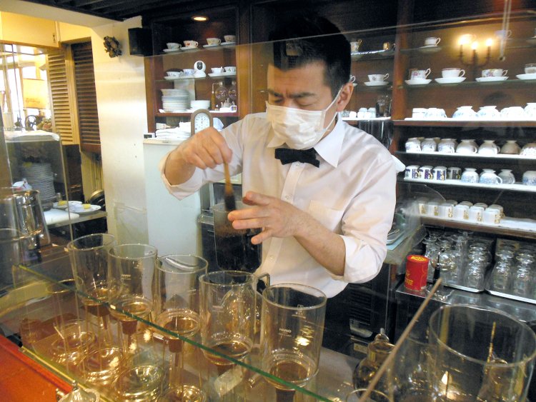 マスターの竹森さん。カウンター越しにサイフォンが5つも並んでいる。
