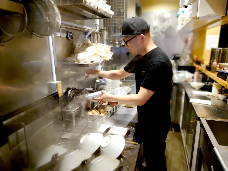 丼を温め、タレ、香油が丁寧に注がれ一杯のラーメンが作られていく。