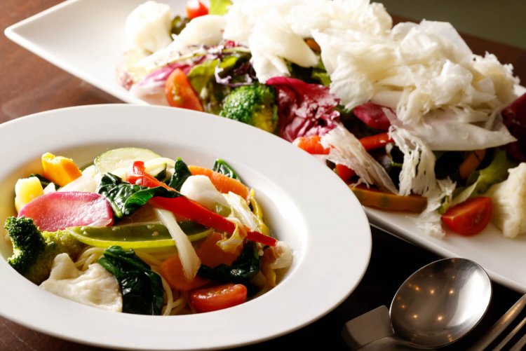 ラスパドゥーラたっぷりのサラダ1400円（右）と季節野菜のスパゲッティ オリーブ味1100円。