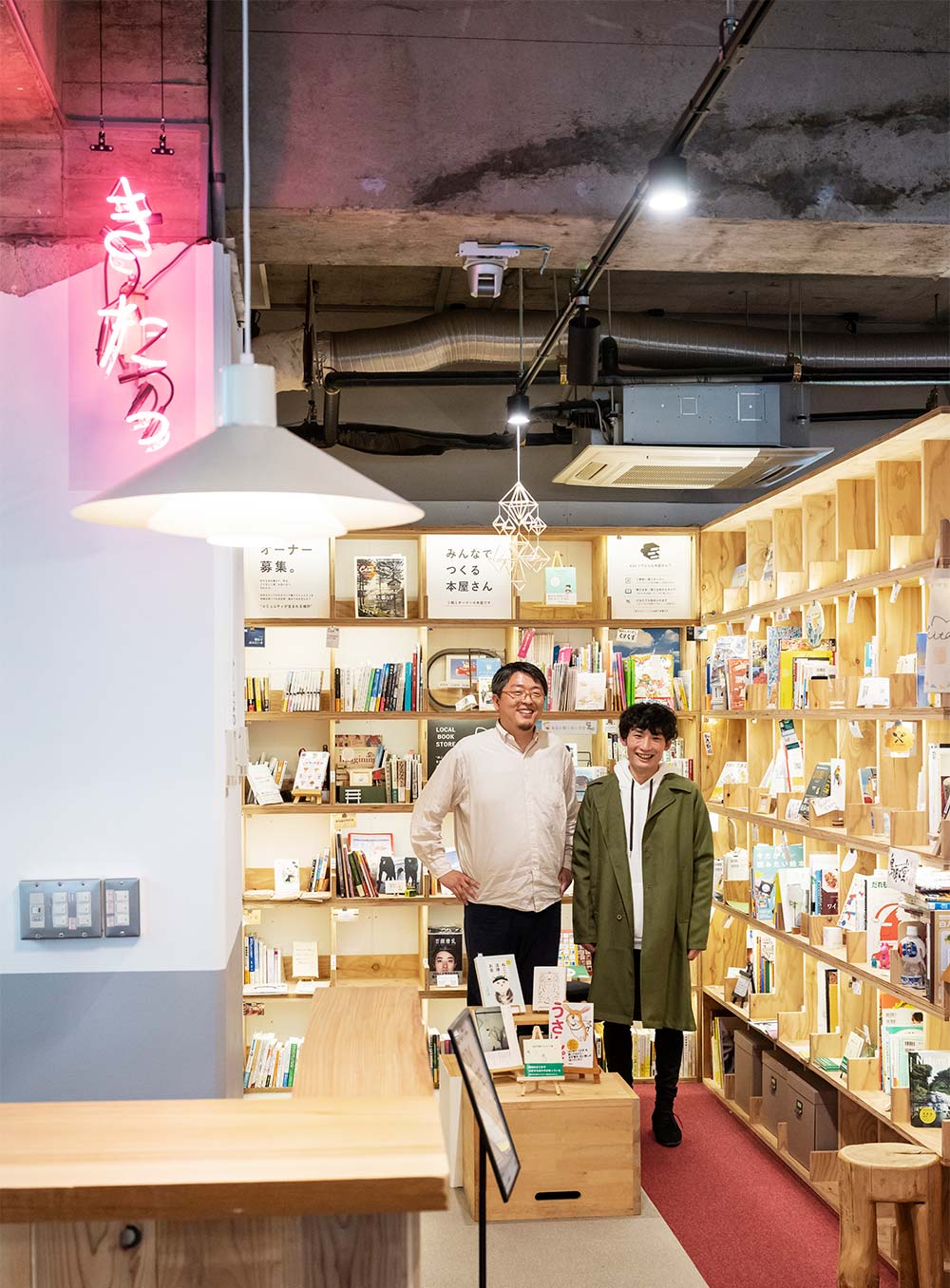 本棚に囲まれた森川さん。オーナーの一人で大学生の島田翔陽さんと。「歴史ある横浜も新しい横浜もどっちも魅力的！」