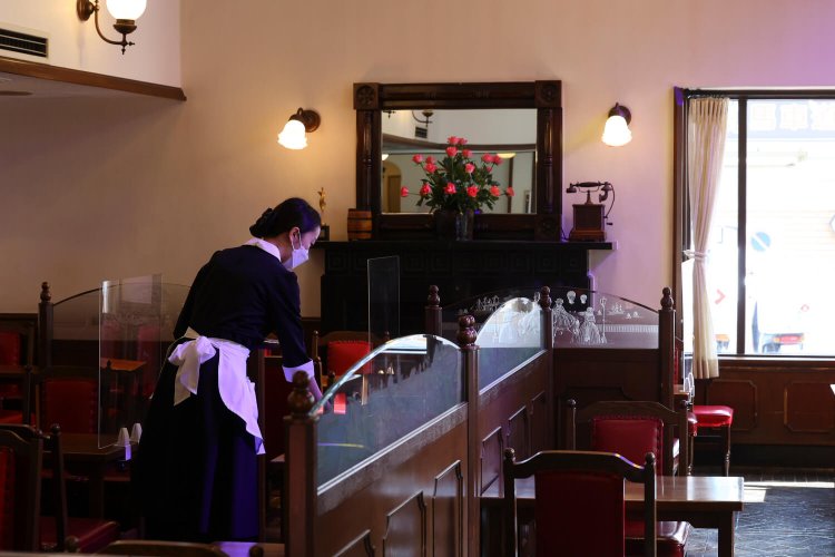 バラが飾られた喫茶室。黒い制服に白いエプロンが映える店員さんも優雅。