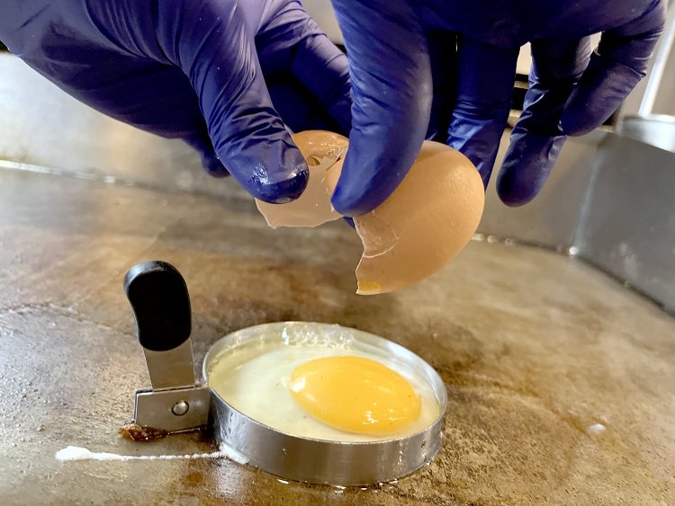 セルクルに入れて丸く焼く目玉焼き。オリーブオイルを加えて周りをこんがり揚げ焼きにする。