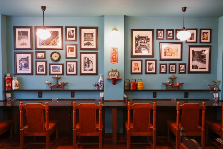 壁の一角に飾られているのは、章さんが撮った中華街の日常風景。他に、中国で仕入れた美人画、花鳥風月画を額装。席ごとに風景が変わる。