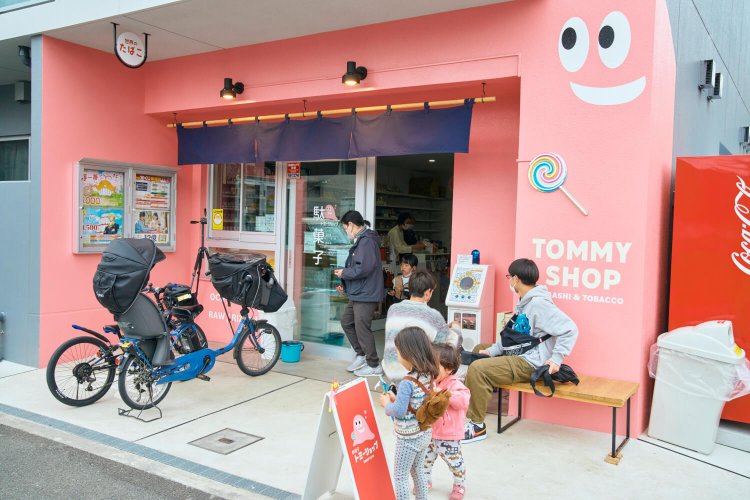 『トミーショップ』の店先。看板の風車で遊び、ベンチで駄菓子を頬張る姿に和む。