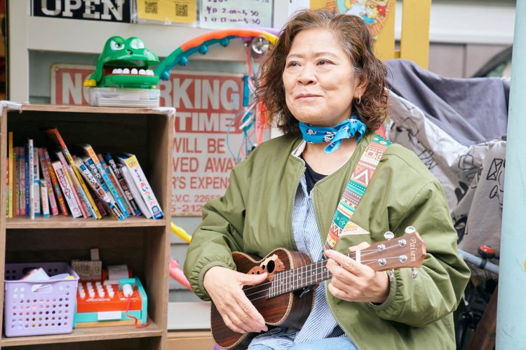 店に飾るウクレレを弾く『だがし屋ボンボンズ』の中沢さん。楽器を持ち寄り、即席演奏会になることも。