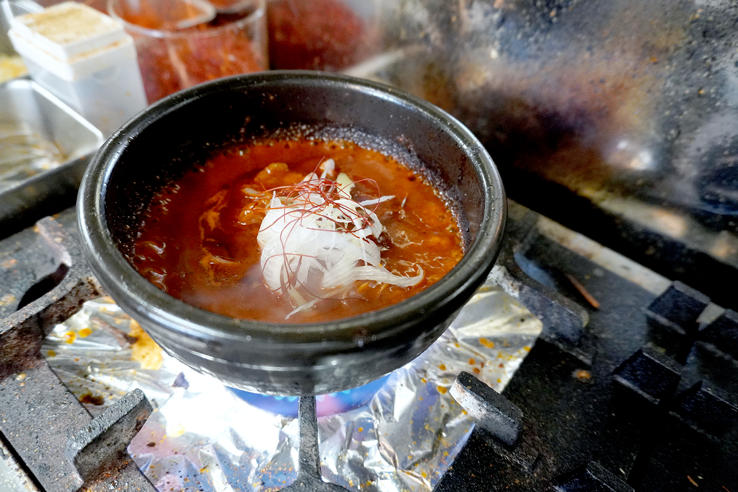 つけ麺のスープが入った石鍋を直接火にかけて、アツアツで提供する。