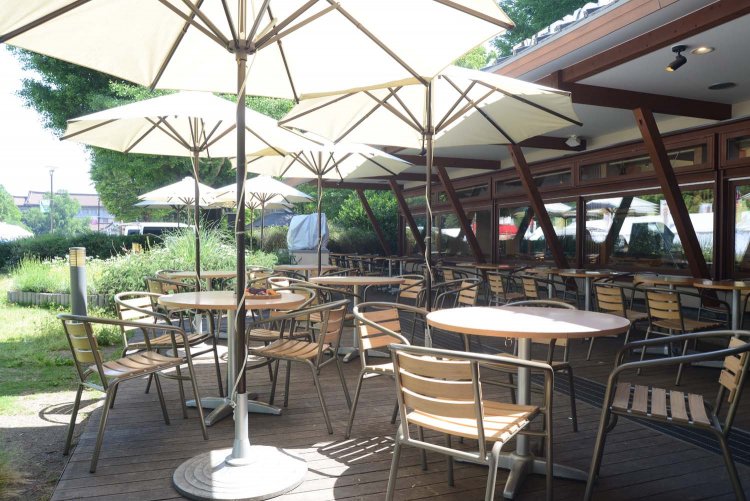 パラソル付きのテーブルが並ぶオープンテラス。天気がいい日にはぜひ利用したい。