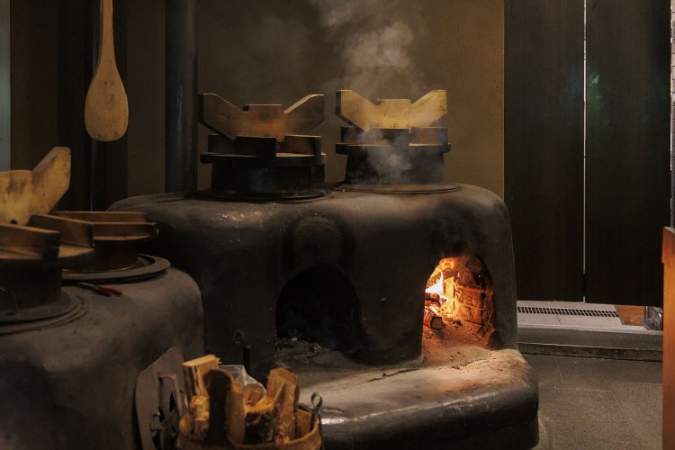 イワナの炊き込みご飯は、カウンター内のかまどで炊き上げる。火が入ると店内は、炎の迫力と薪が燃える匂い、そしてご飯の炊ける香りで包み込まれる。