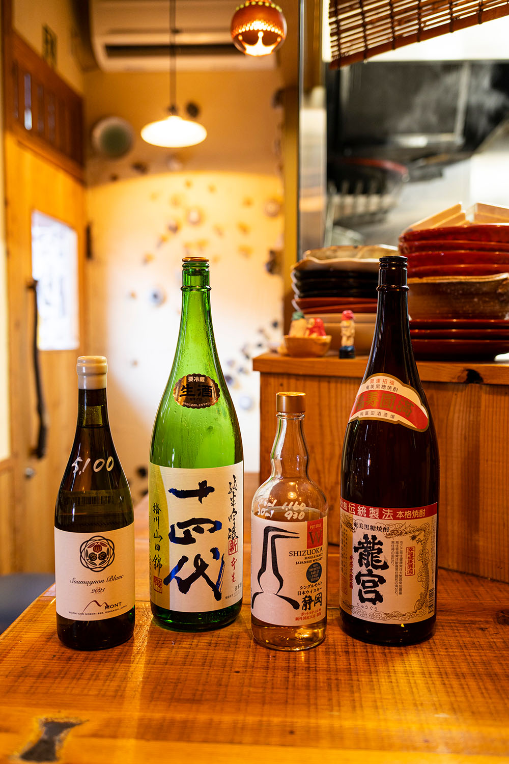 黒糖焼酎「龍宮」（右）の前割り700円など。日本酒は希少銘柄も120㎖ 500円均一。北海道産ワインも。