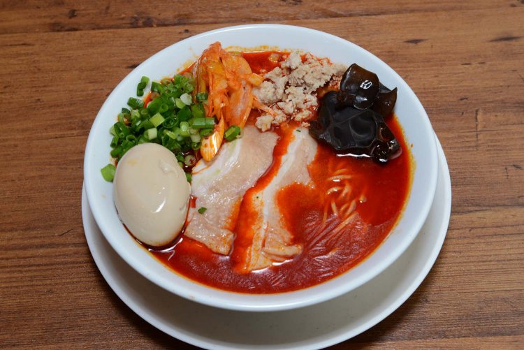 とろりとした半熟の味玉がトッピングされた味玉鶏赤湯らーめん1130円。