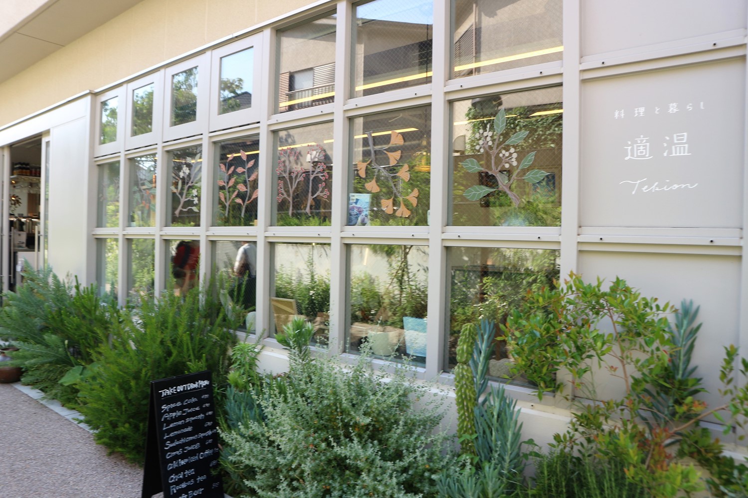 緑に囲まれた、癒やされる店構え。窓に描かれた植物のイラストも印象的。