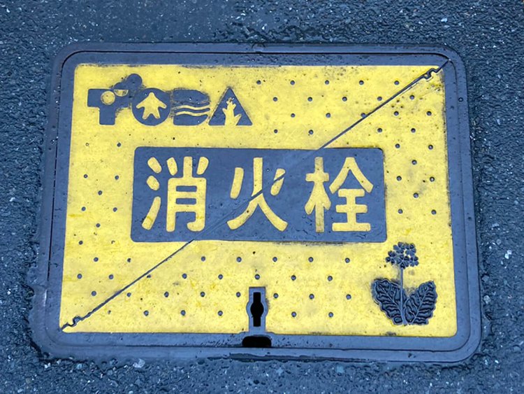 「ハーモナイズドマーク」と名づけられた戸田市のロゴと、市の花であるサクラソウがあしらわれている。「ハーモナイズドマーク」の制定が平成5年なので、それ以降の設置ということか（戸田）。