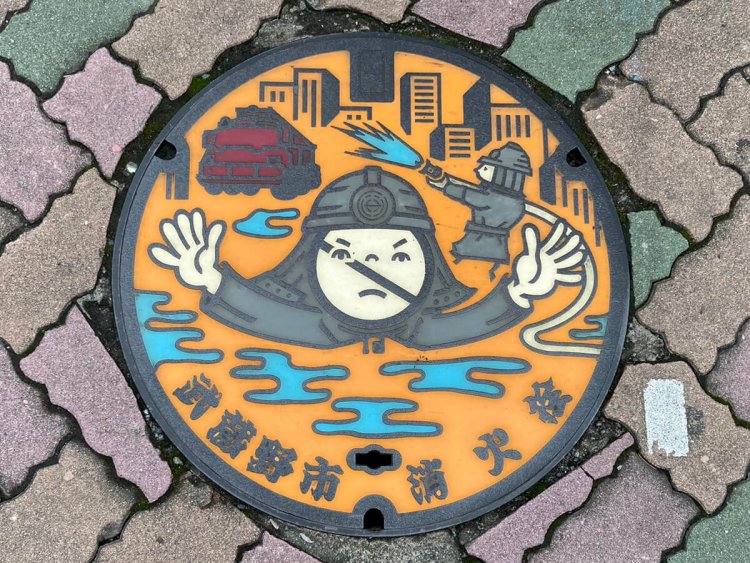 先に挙げた四角蓋と同じデザイン。当初「ゴーストバスターズ…？」と思ったが、恐らく「消火栓蓋の上は駐車禁止だよ」という顔なのだ（吉祥寺）。