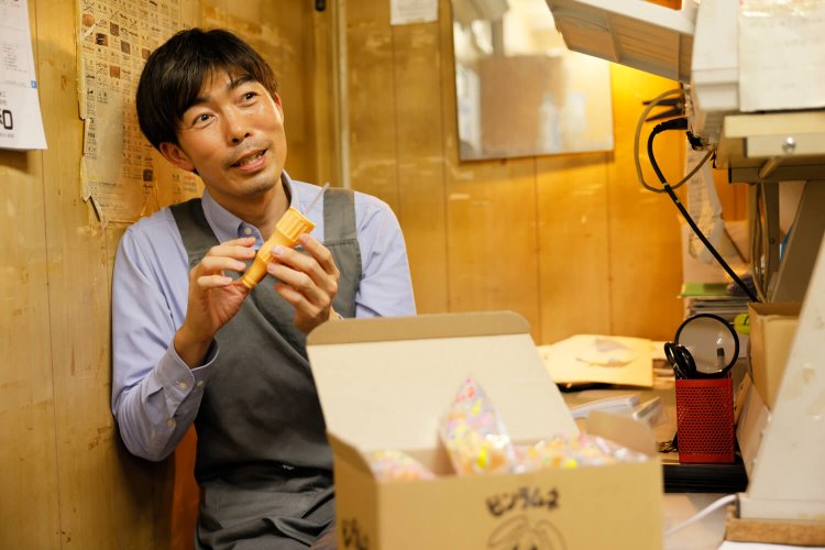 3代目の岡田さん。ストローはおしりの方が刺しやすい。「ゆっくり吸ってみて」。