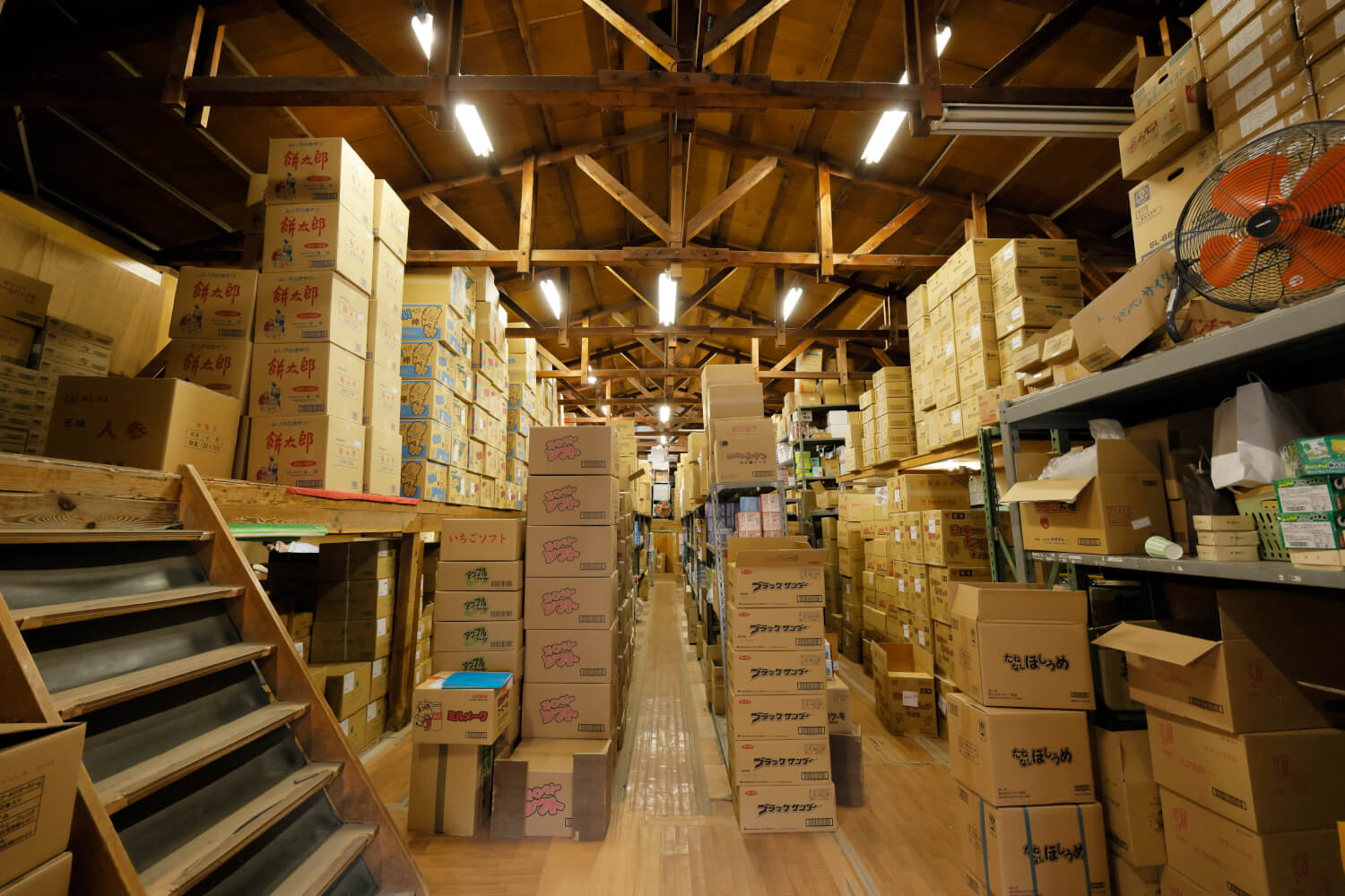 風格すら漂う木造倉庫には、天井に届くほど荷物が詰まる。