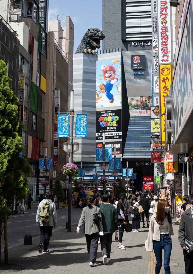 ゴジラが『TOHOシネマズ新宿』の屋上から顔をのぞかせるセントラルロード。