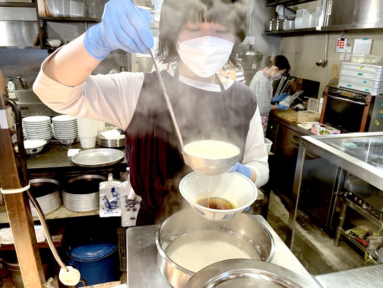 豆乳スープを注ぐ店長の内田さん。