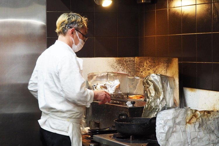 炭火で銀鱈を焼く畔田さん。いい香りがし始めた……！