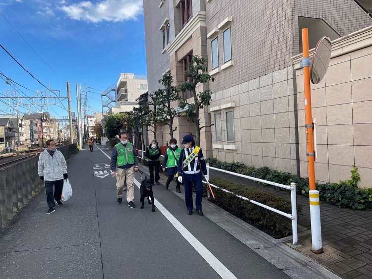 町会の人や警察官らとともにパトロールを行うこまる君。この活動によって車やバイクの違法駐車や違法駐輪が減ったという。