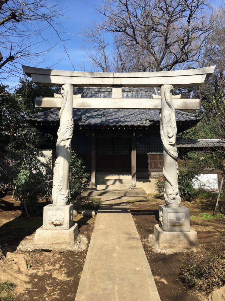 「高円寺稲荷神社」の鳥居は龍が巻きつく珍しいもの。