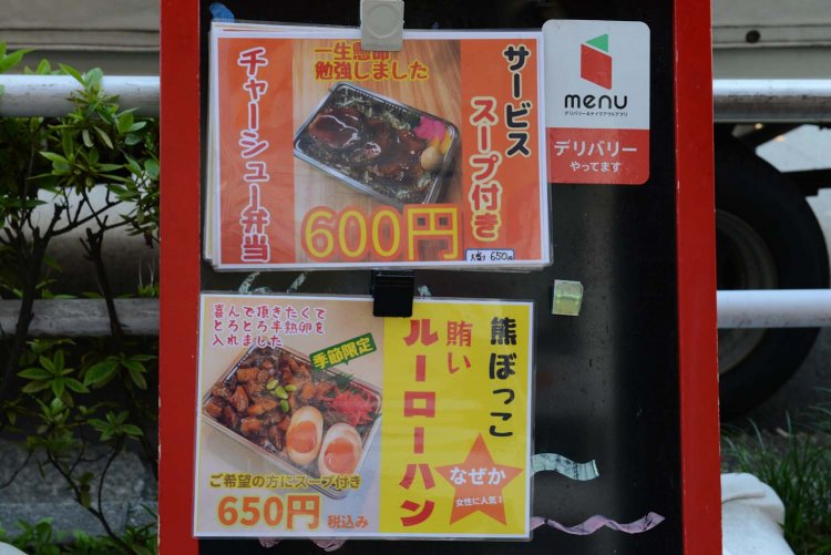 店頭の看板に貼られた弁当メニュー。