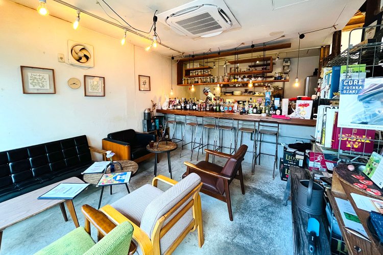 お酒の瓶が並ぶカウンターに、テーブル席やソファ席、脇には本棚も。