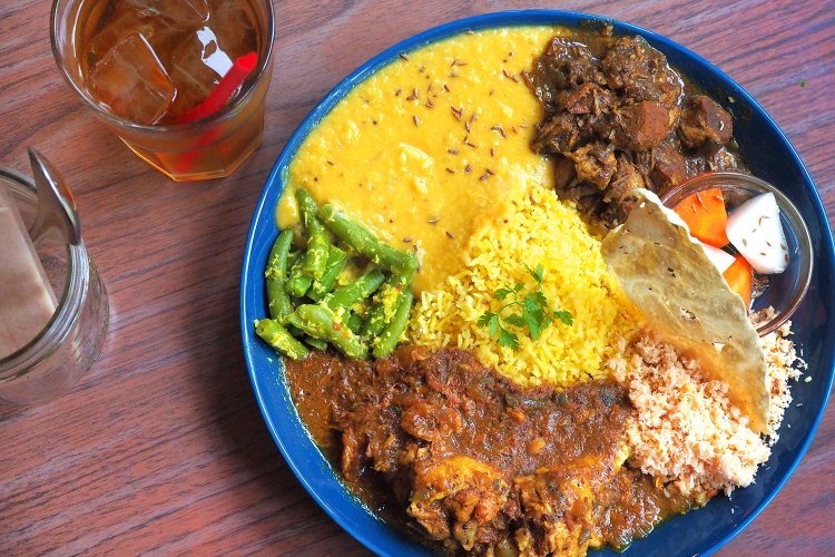 右上から時計回りに、ポークカレー、自家製ピクルス、パパダム、ポルサンボル、チキンカレー、インゲンのテルダーラ、レンズ豆カレー。